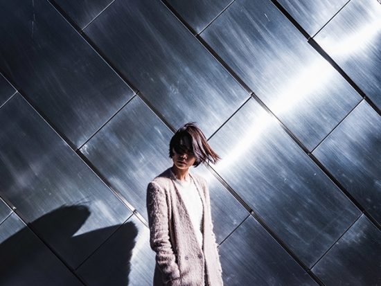 Woman in Tokyo standing in front of a reflective wall.